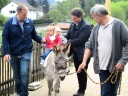 Die Kinder reiten auf dem Esel Julius